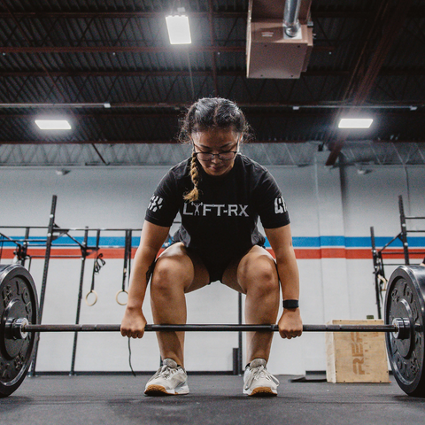 asian female athlete about to lift weights