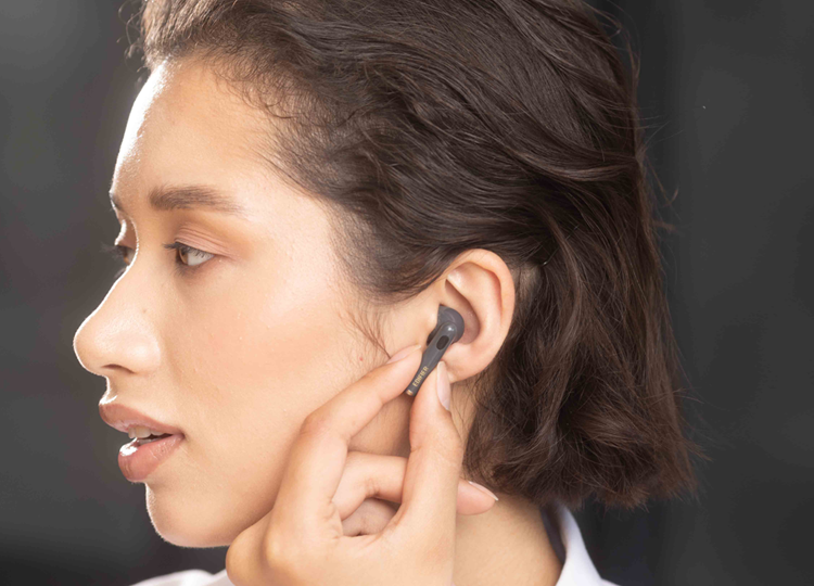 A woman wearing EDIFIER to-u6+ pink earbuds with 4 sizes of ear tips