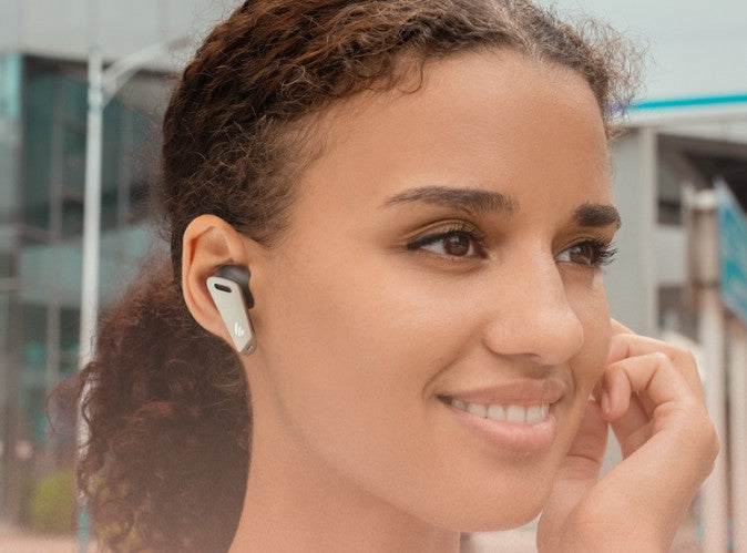 the woman is going to wear the edifier earbuds