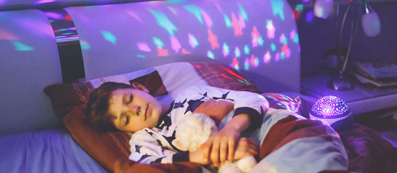 Enfant qui dort avec sa veilleuse projection