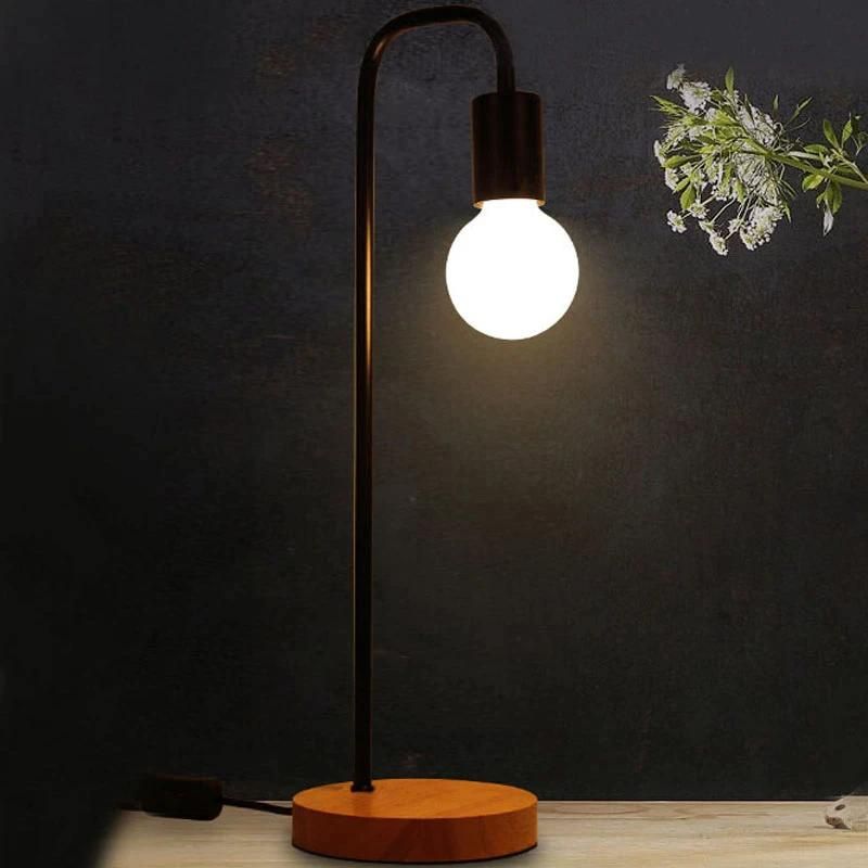 la lampe de chevet bois et métal vintage allumée sur un meuble