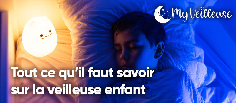 Enfant qui dort avec une petite veilleuse dans son lit