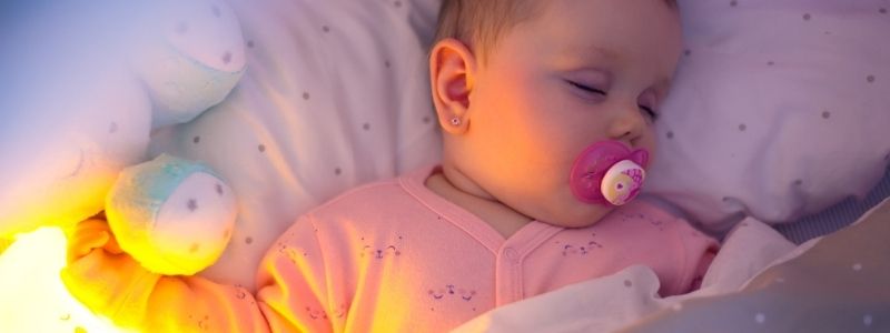 enfant qui dort avec une veilleuse silicone allumée