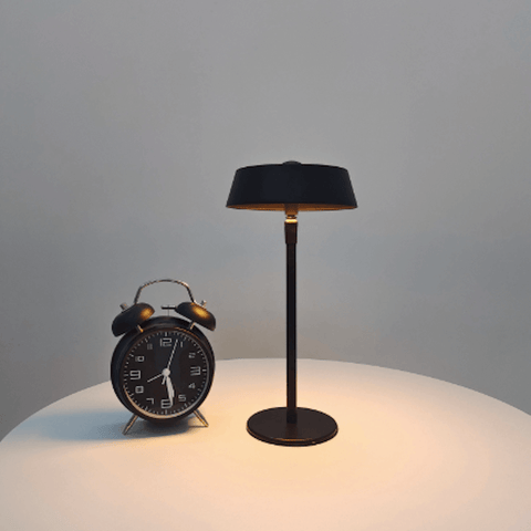 lampe de chevet tactile sans fil design sur une table a coté d'un réveil