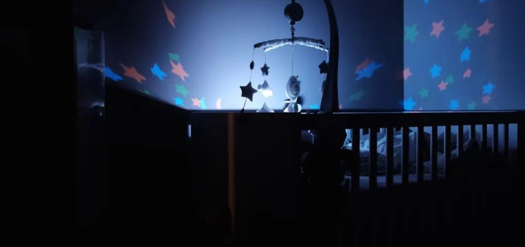 veilleuse projection allumée dans une chambre de bébé