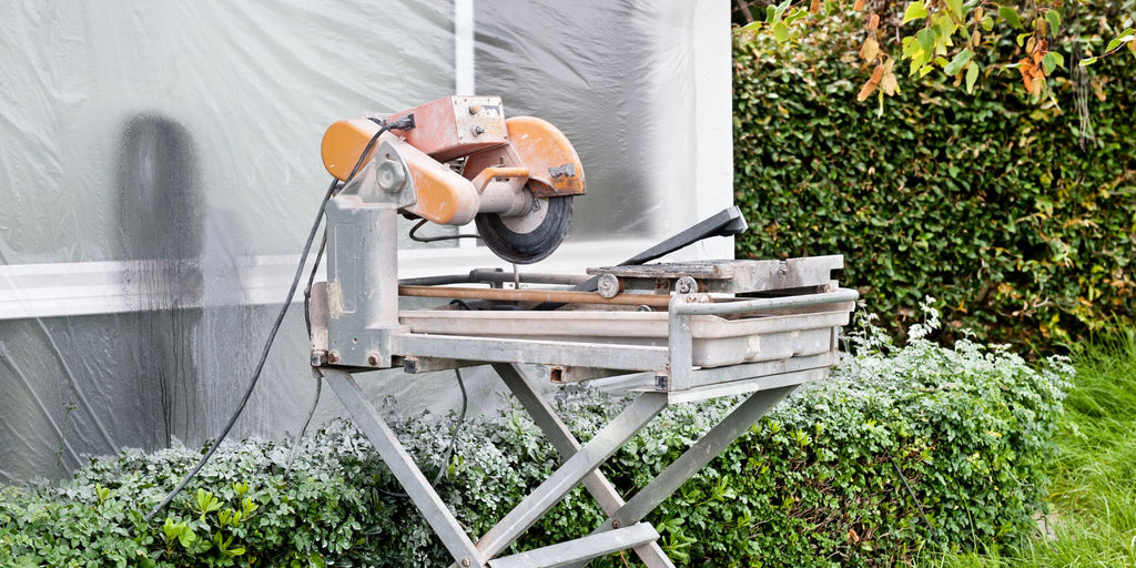 Cut 2cm patio slab with the table saw - banner image. Do-it-yourselfer has set up a table saw in the garden for cutting patio tiles with a porcelain stoneware diamond cutting disc