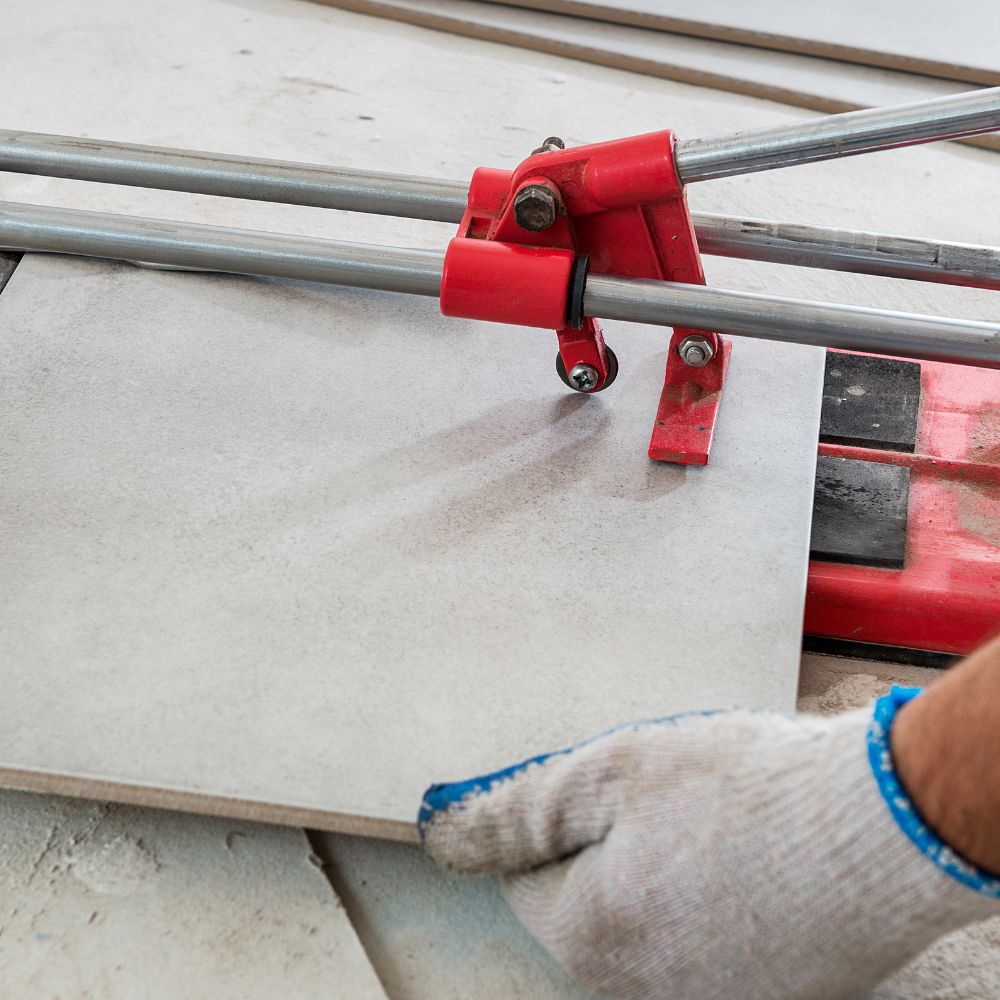 Wandfliesen werden mit einem Fliesenschneider zurecht geschnittten