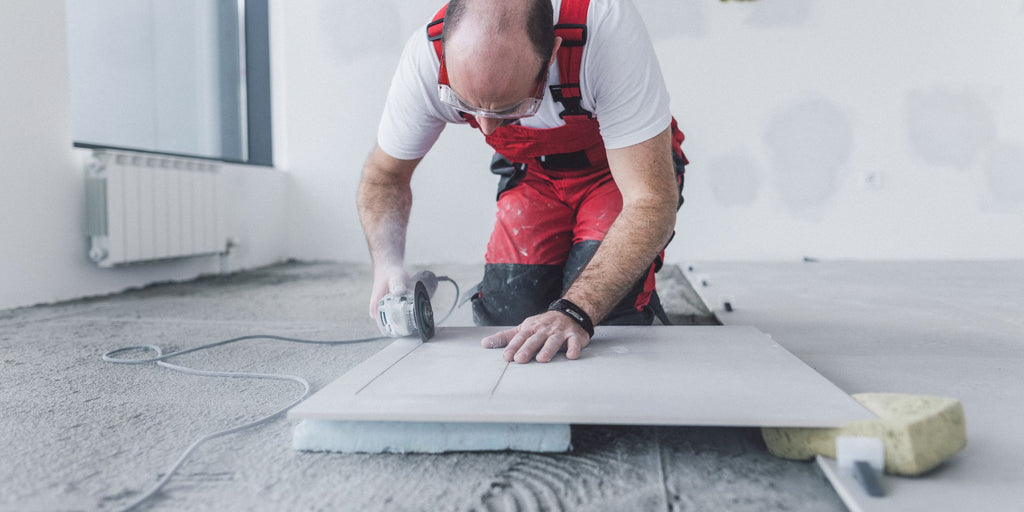 Handwerker beim Großformat Fliesen schneiden mit der Flex / Winkelschleifer