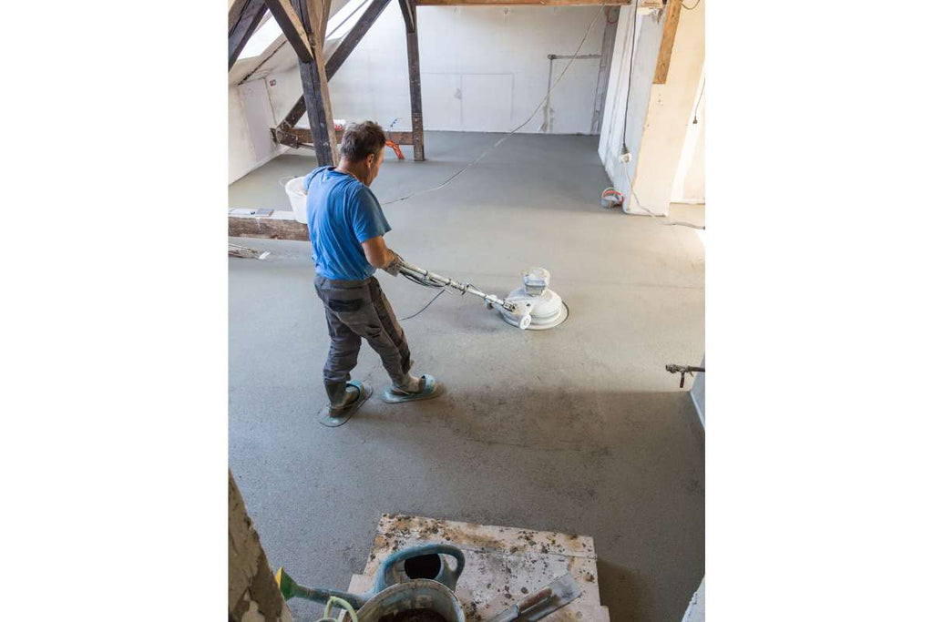 Heimwerker beim Vorbereiten des Estrich Boden im Wohnzimmer um Fliesen zu verlegen