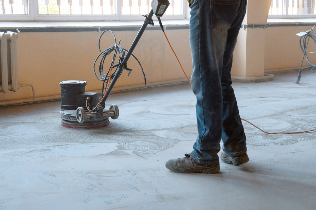 Poncer le sol en béton avec une machine à plancher