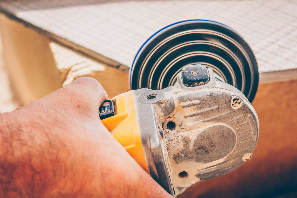 A diamond grinding pad mounted on the angle grinder used for grinding tiles