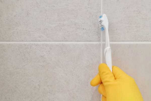 Tile joints are cleaned with a toothbrush
