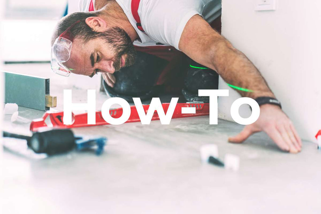 Tiler laying tiles and using a tile leveling system with clamps