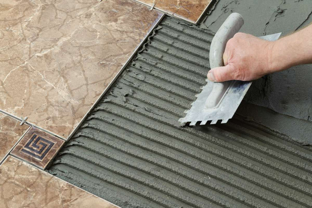 Tile adhesive is applied to the floor to lay tiles