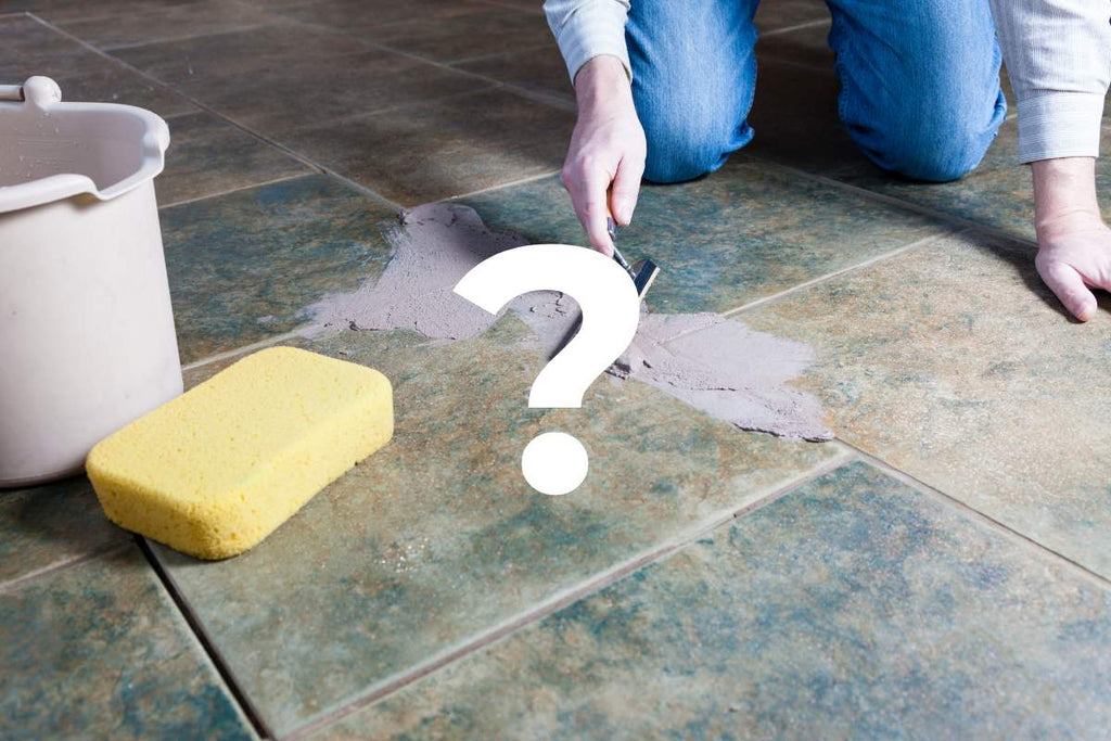 A craftsman spreading the grout with a notched trowel