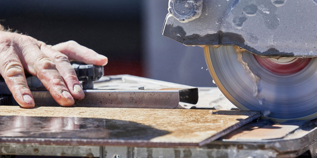 Craftsman cutting tiles with the wet cutter - with water supply and diamond saw blade