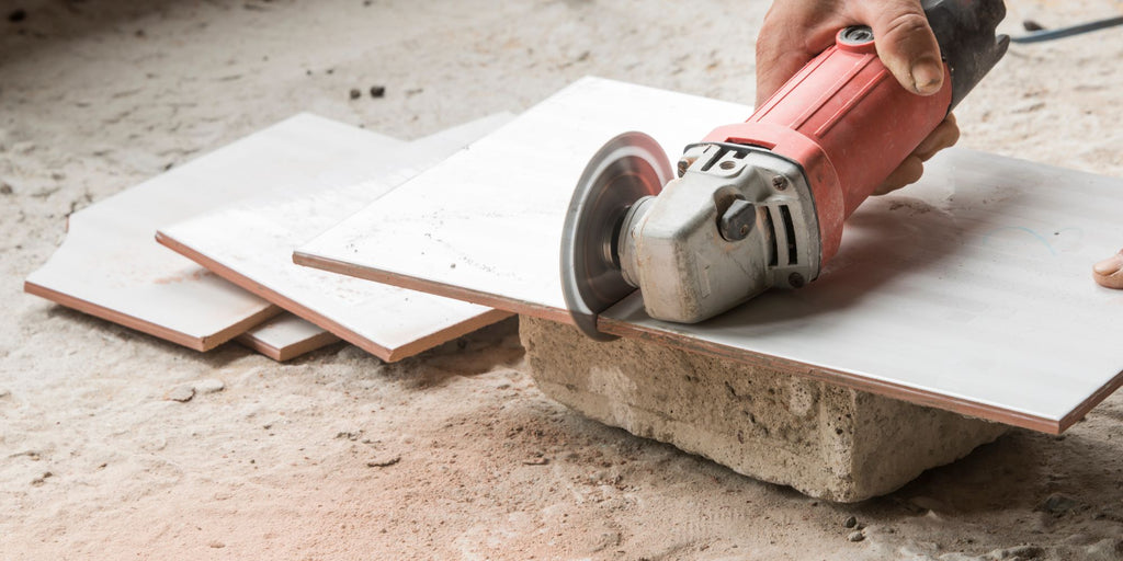 Ratgeber_Fliesen Cutting baseboards_ Application image _ Craftsman cuts baseboards for the bathroom with an angle grinder