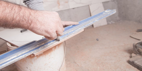 Artisan marquant le bord coupé d'une dalle de béton