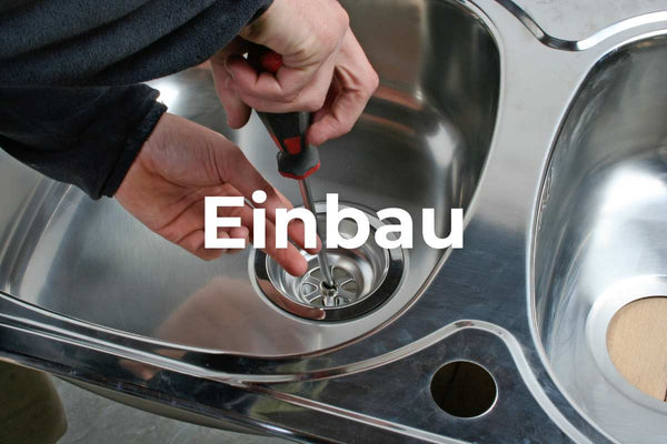 Ein Waschbecken aus Edelstahl wird von einem Handwerker eingebaut