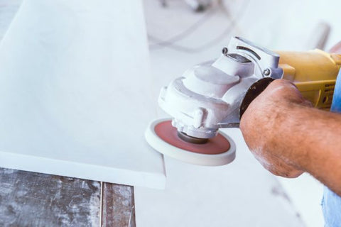 The picture shows a do-it-yourselfer polishing a granite surface with an angle grinder and appropriate abrasives