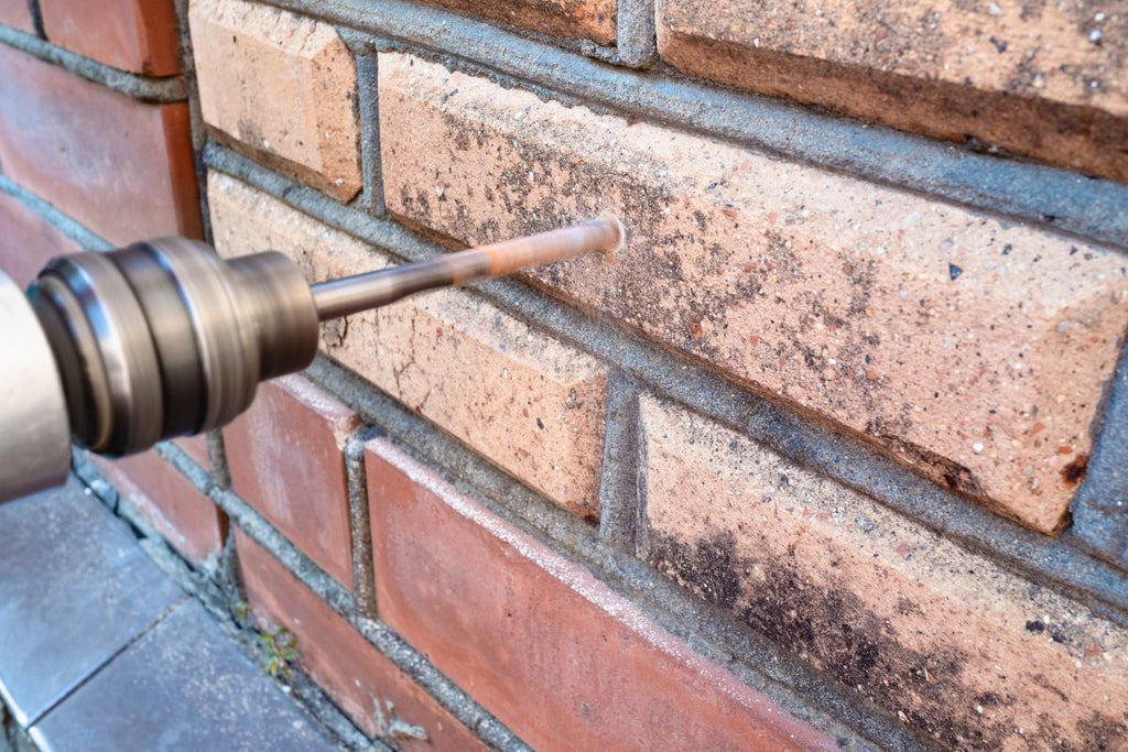 Brick in masonry is drilled with a drill and a masonry drill bit