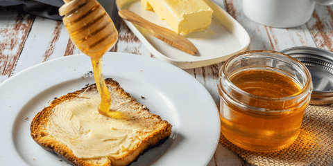 toast with butter and pot of honey and honey spoon