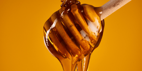 gather by manuka honey dripping from honey spoon