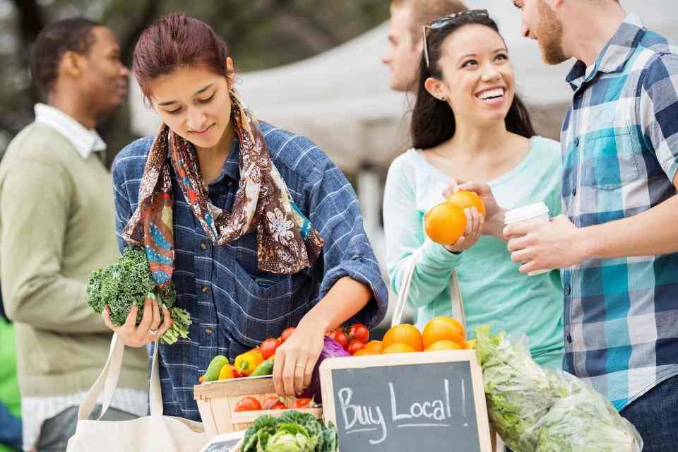 Image of people shopping at the local farmers market to be better community members