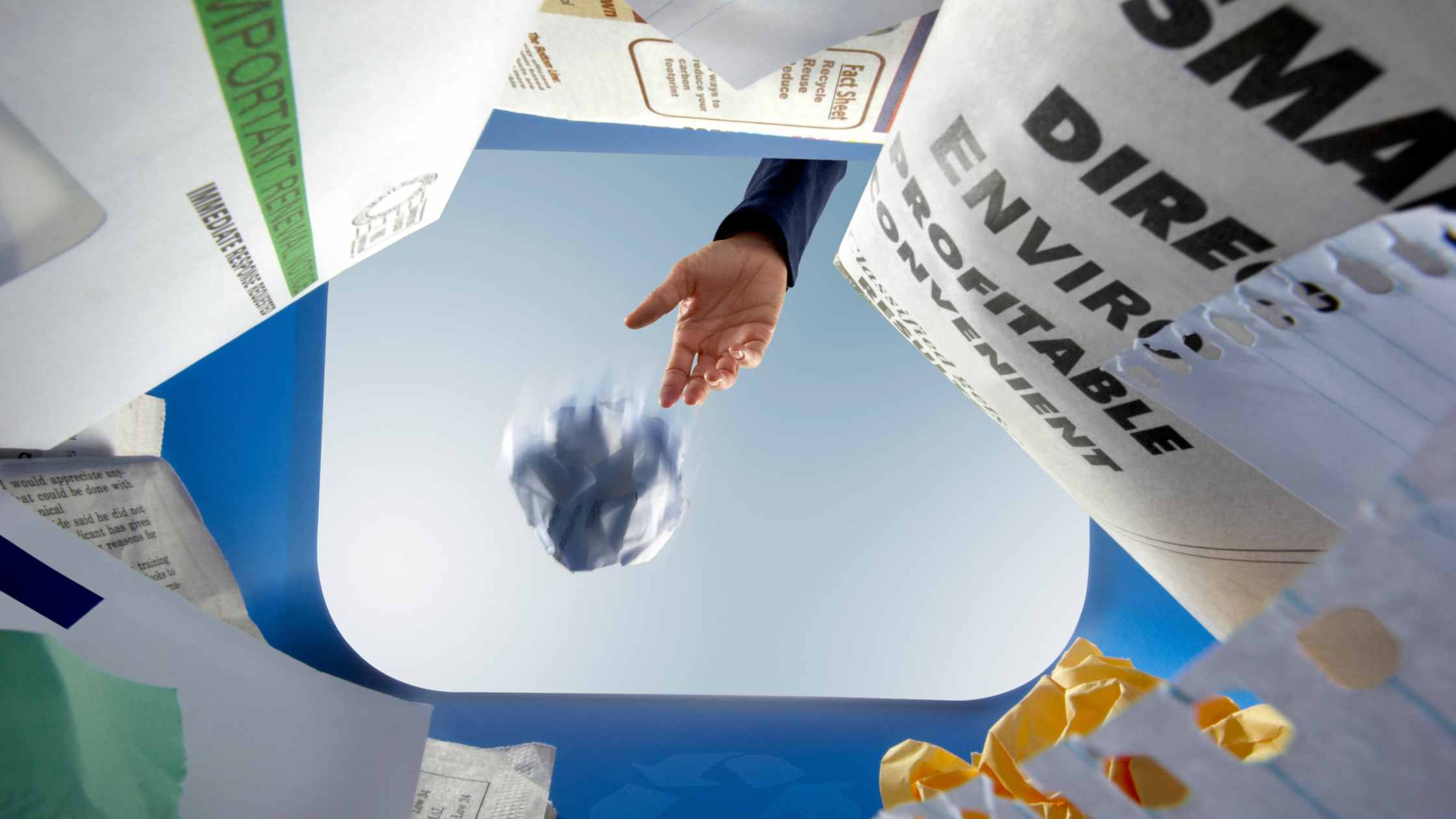 image of paper being tossed in bin to become recycled paper