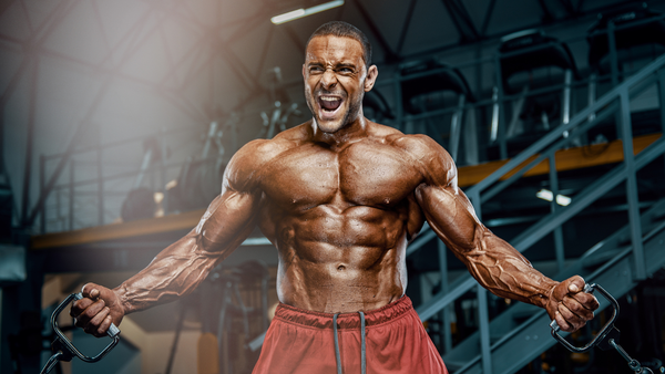 A bodybuilder athlete looking cut while doing a standing chest butterfly with resistance bands.