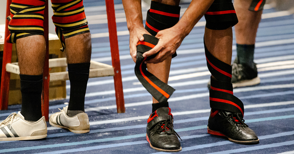 Many powerlifters use equipment such as knee wraps or lifting shoes to assist with good technique