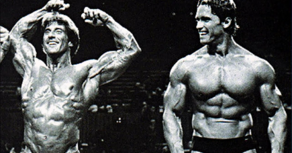 Pro bodybuilders Arnold Schwarzenegger and Frank Zane posing on stage