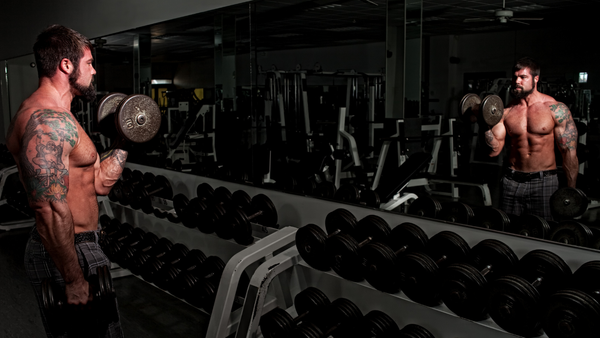 Professional bodybuilder performing bicep curls at the gym.