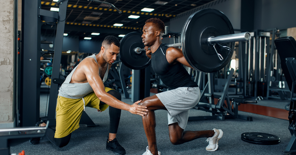 Athlete practicing lunges in the gym with trainer