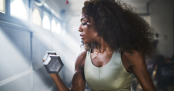 Woman performing dumbbell curl with palms facing inward