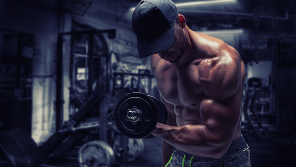 Professional male bodybuilder athlete curling weights to build and tone muscle.