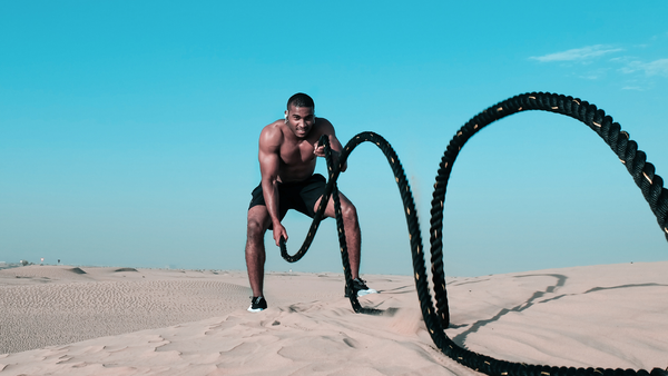 Bodybuilder working out throwing ropes.