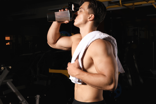Athlete drinking pre-workout before his weightlifting session