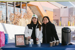 Photo of U of C volunteers standing at Hot Chocolate stand.