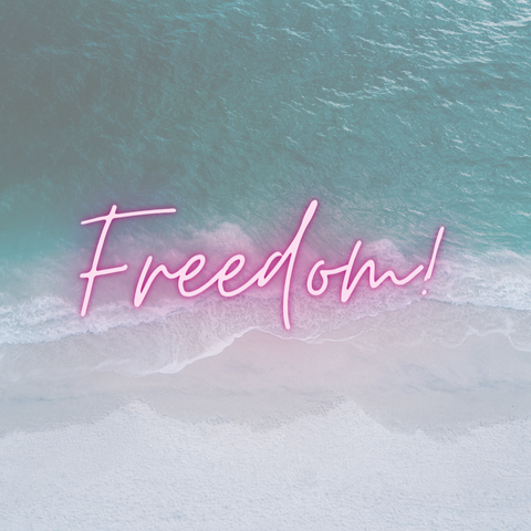 the word freedom in backlit text on an ocean background