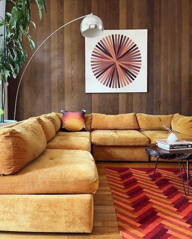 vibrant 70s room with velvet couch and wood panelled walls