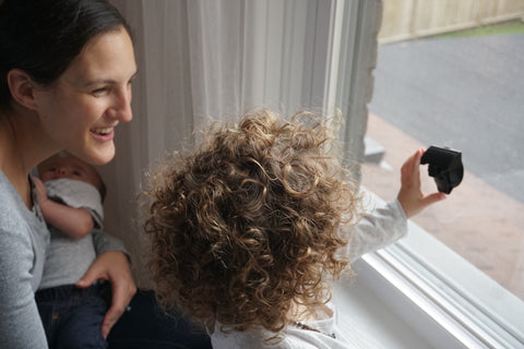 mom and kid putting up sleepout portable blackout curtains 