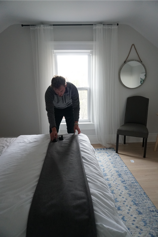 man getting curtains ready to hang 