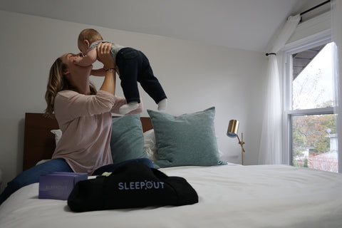 woman with baby in bed playing 