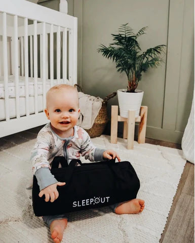 baby sitting on floor with curtains 