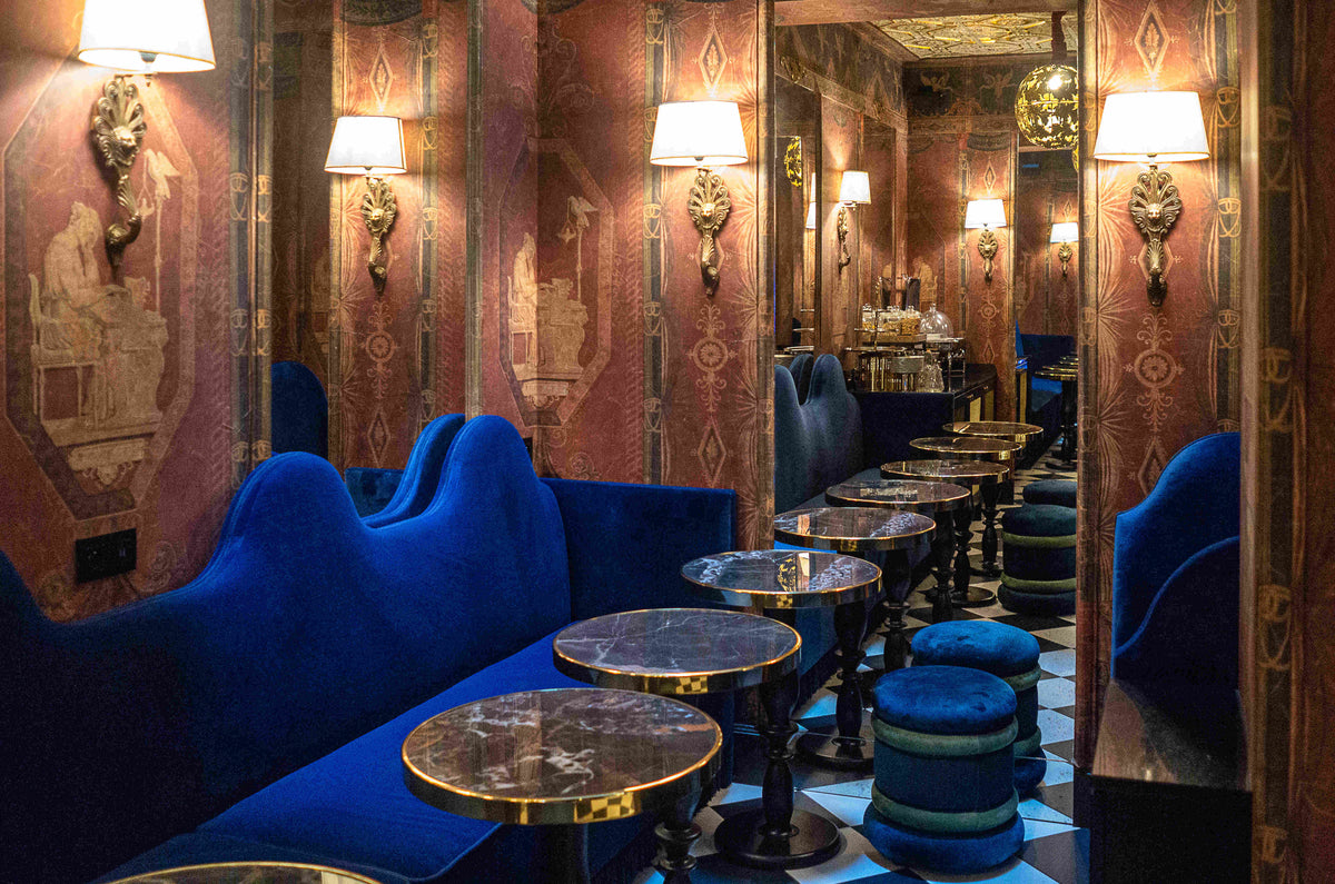 Bar de l'hôtel avec les banquettes, miroirs et tables de bar