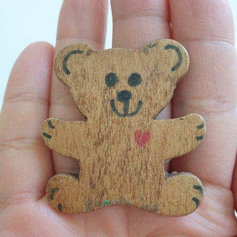 Small brown stencilled bear in the palm of a hand