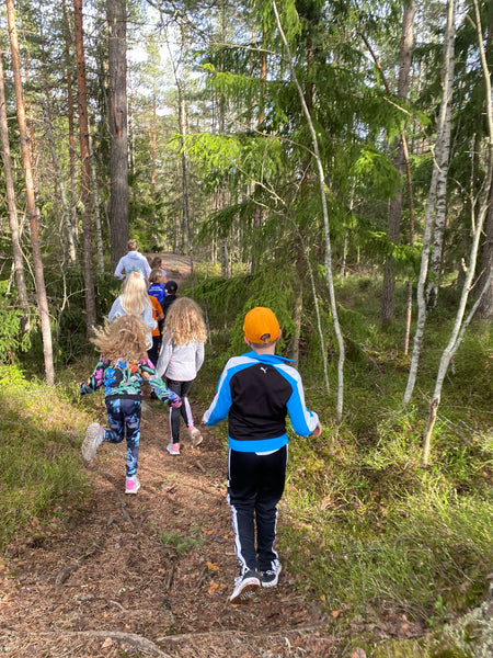 Children run downhill in the forest
