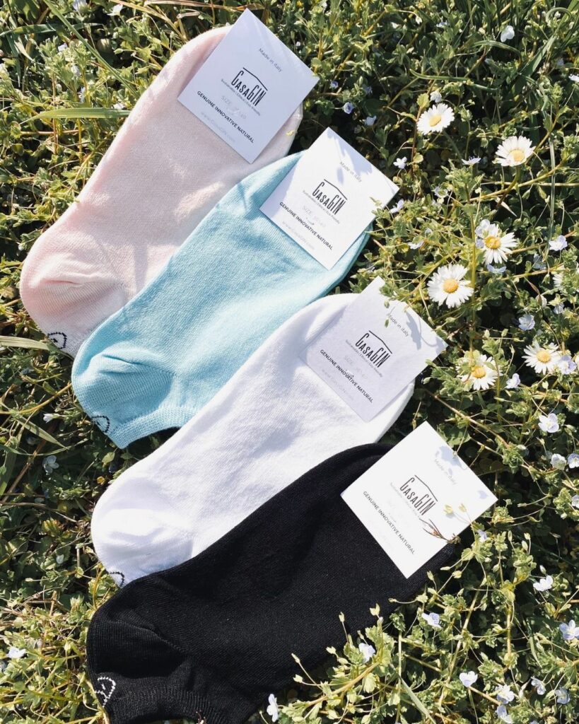 Short socks in organic cotton lying on a meadow of flowers
