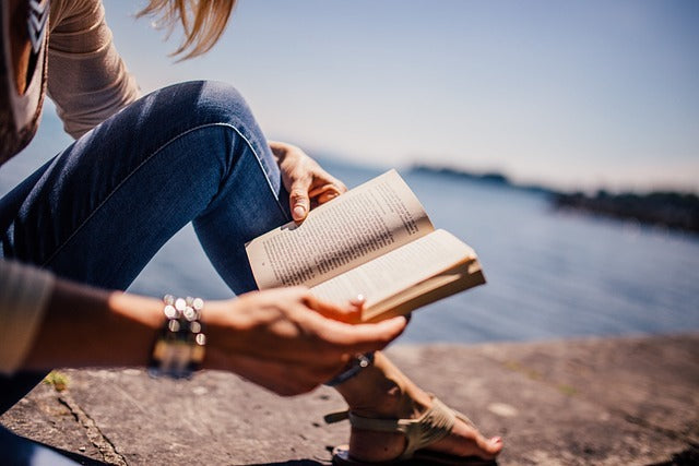 donna che legge un libro in spiaggia